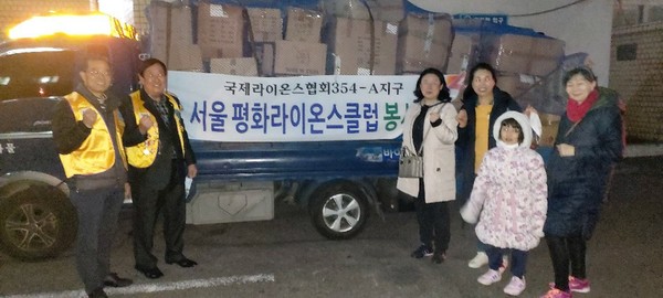 국제라이온스협회 354-A 지구 서울 평화라이온스클럽 오용균 회장(왼쪽 두번째) 송란교( 왼쪽 첫번째)총무가 물품전달 화물차 앞에서 글로벌 한부모센터 관계자들과 기념촬영을 하고 있다