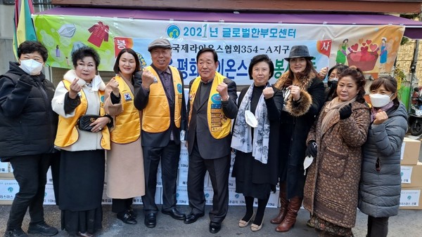 서울평화라이온클럽회원들과 글로벌 다문화 한가정 새터민 회원들이 전달된 김장김치 앞에서 함께한 기념 사진